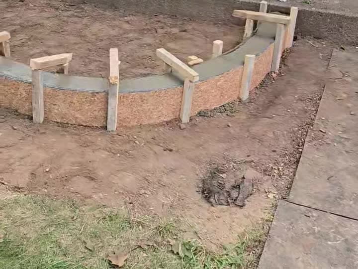 Freshly poured curved concrete landscape curbing still in wood forms, Oakton, VA